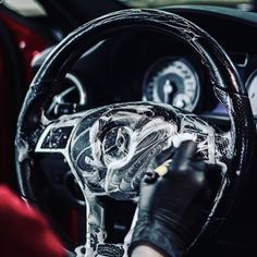 a person is cleaning the inside of a car steering wheel with a cloth on it