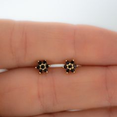 Dainty flower shaped stud earrings. Perfect for pairing with multiple piercings. Available in Black or Black with White CZ Stone DETAILS * Thick plating of 14k Gold or Rhodium over 925 Sterling Silver * Sold as a Pair * Hypoallergenic and nickel-free * 5 mm x 5 mm * Also available in white cz, ruby, sapphire or emerald Huggies on Model: https://www.etsy.com/listing/708078947/sapphire-huggie-earrings-gold-cz-huggies?ga_search_query=black%2Bhuggies&ref=shop_items_search_1&pro=1 Made with 1 Black Stone Studs In Gold, Black Stone Earrings Gold, Stone Earrings Studs, Bali Design, Black Stone Earrings, Black Diamond Earrings Studs, Nose Pins, Black Studs, Black Diamond Studs