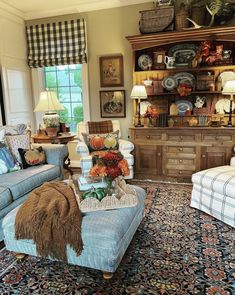 a living room filled with lots of furniture and decor on top of a blue rug