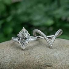 two engagement rings sitting on top of a rock