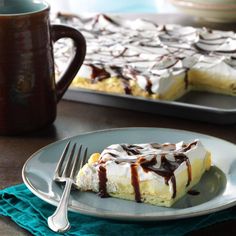 a piece of cake sitting on top of a plate next to a cup and fork