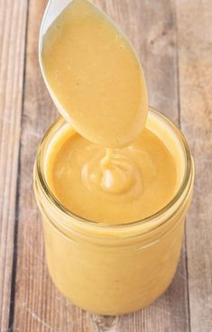 a spoon full of peanut butter on top of a jar