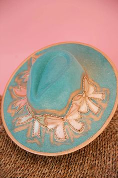 Add a touch of glam to any outfit with our BOW FANCY RANCHER HAT. This blue rancher hat features gold accents and unique bow patches with gold painted outlines. A playful addition to your accessory collection! This hat is ONE OF A KIND, created by our owner Stephanie. To receive item quicker, expedited shipping is avai Handmade Gold Hat For Kentucky Derby, Gold Curved Brim Hat Band For Party, Gold Hat Band For Party With Curved Brim, Gold Wide Brim Fedora For Party, Gold Fedora With Curved Brim For Party, Bohemian Gold Party Hat, Gold Bohemian Party Hat, Handmade Gold Hats For Party, Handmade Gold Party Hat