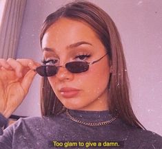 a woman wearing sunglasses and looking at her reflection in the mirror with an interesting quote on it