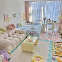 a living room filled with lots of furniture next to a bed and desk in front of a window