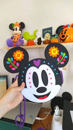 a person holding up a mickey mouse mask