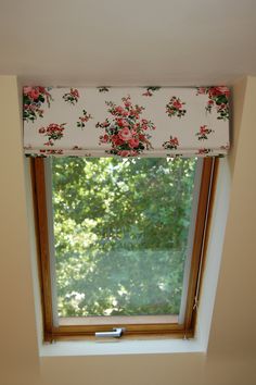 a window with a flowered valance hanging from it's side