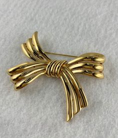 Beautiful 3 ribbon bow. Marked Trifari with a crown over the T. Elegant Gold Brooches With Ribbon, Classic Bow Brooch As Gift, Classic Bow Brooch For Gift, Vintage Ribbon Brooches For Formal Occasions, Classic Bow Brooches For Gift, Vintage Ribbon Brooches, Gold Ribbon Bow For Gifts, Bow Brooch, Crown Trifari