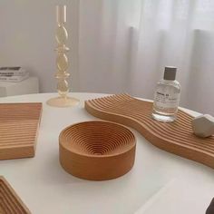 a white table topped with wooden trays and vase next to a bottle of water