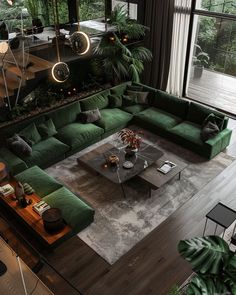 a living room filled with lots of green couches and tables in front of large windows