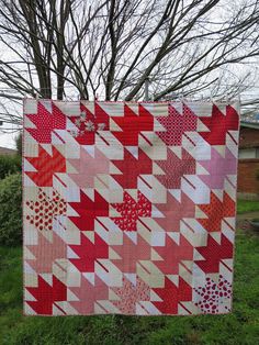 a red and white quilt hanging from a tree