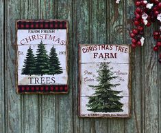 two christmas tree farm signs hanging on a wooden wall