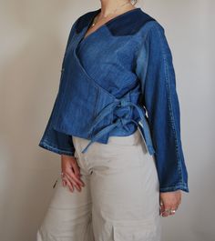 The Ruby Wrap Around is a stylish collarless denim jacket. This wrap around jacket has two side fastenings to create a kimono style finish.  When to wear? This lose fit tie jean jacket is the perfect extra layer, Swap that cardigan and don your Ruby Wrap Around.  Jacket sizing and details: one size, models are sizes 12-14(uk) can fit between 10-16 (uk) Chest/Bust 44" 112cm - Back length 20" 51cm - Sleeve 23" 58.5cm. Tie fastenings   *Every item at Reclaimed Roundabout is completely unique and on Collarless Denim Jacket, Brighton England, Upcycled Jeans, Upcycle Jeans, Kimono Style, Kimono Fashion, Suit Jackets, Upcycle Clothes, Zero Waste