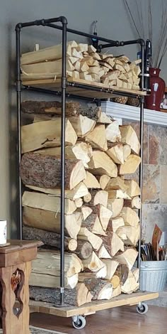 a stack of logs sitting on top of a wooden table next to a fire place