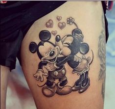 an image of mickey and minnie mouse tattoo on someone's thigh, with the caption