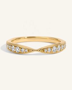 a yellow gold wedding band with diamonds on the sides and an elegant twist in the middle