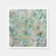 a pile of sea glass sitting on top of a white table next to a wall