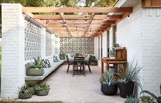 an outdoor dining area with potted plants on the patio