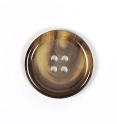 a brown button with three white buttons on the front and back of it, against a white background