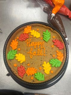 a birthday cake decorated with leaves and the words happy fall on it's side