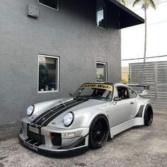 a silver sports car parked in front of a building