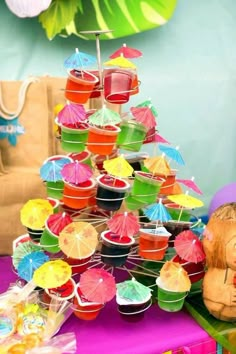 a table topped with lots of cupcakes covered in umbrellas and muffin cups