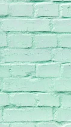 a green brick wall painted in pastel shades