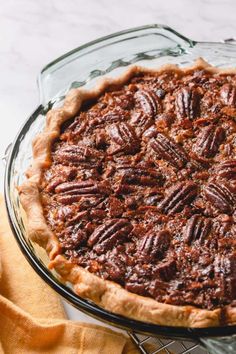 a pecan pie sitting on top of a glass plate