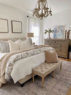 a bed room with a neatly made bed and a chandelier