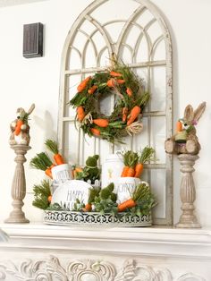 a white fireplace mantel topped with carrots and greenery next to a wreath