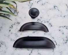 two black door handles on a marble surface