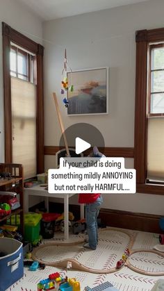 a child is playing with toys in a room that has windows and wooden trimmings on the floor