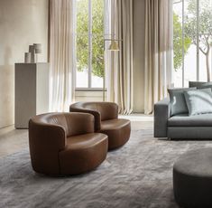 a living room filled with lots of furniture next to a large window covered in curtains