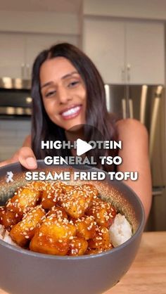 a woman holding up a bowl of food with sesame fried tofu in it and the caption high protein general tso sesame fried tofu