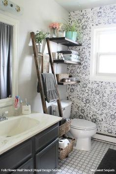 the bathroom is decorated in black and white with flowers on the wall above the toilet