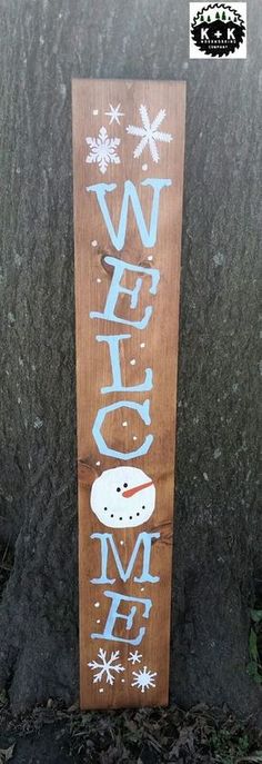 a wooden sign that says welcome home with snowflakes on it and the word winter written in blue