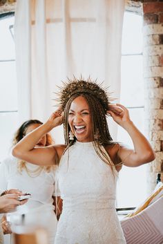 a woman with dreadlocks standing next to another woman in a white dress and smiling