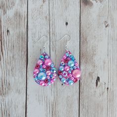 "These teardrop earrings are made with resin and glitter. They are then covered with faux pearls and glass rhinestones. The blue and pink confetti glitter base peeks between the rhinestones and pearls. The pearls and rhinestones are hand placed individually. Their placement differs on each earring, making each one unique. Earring size (not including fish hook): 1.5 inches long The fish hook ear wires are made with a nickel free stainless steel. 925 sterling silver and gold tone ear wires are ava Pearl Teardrop Earrings, Unique Earring, Pink Confetti, Earring Making, Glitter Hearts, Blue Rhinestones, Valentine Heart, Blue And Pink, Teal Colors