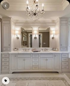 a large bathroom with two sinks and a chandelier