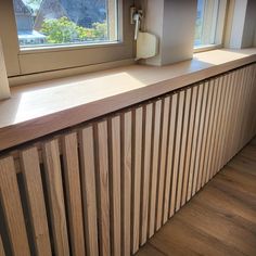 a window sill with wooden slats in front of it and a phone on the wall