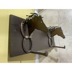 a metal horse head mounted to the side of a wall next to a tile floor