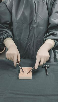 a person wearing gloves and holding scissors in their hands