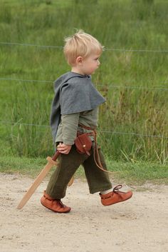 a little boy walking across a dirt road holding a baseball bat and wearing sandals with the words when mom sends you to school, but you get to go