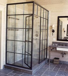 a bathroom with a walk in shower sitting next to a sink and a mirror on the wall