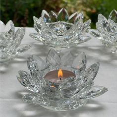 several clear glass candlesticks sitting on top of a table