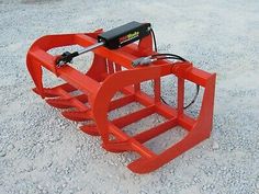 a red snow plow sitting on top of gravel