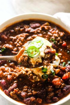 a white bowl filled with chili and cheese