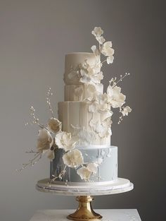 a three tiered cake with white flowers on top