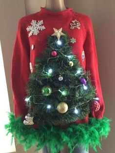 a christmas sweater with lights on it and a tree in the middle, is displayed