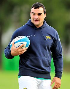 a man holding a blue and white rugby ball